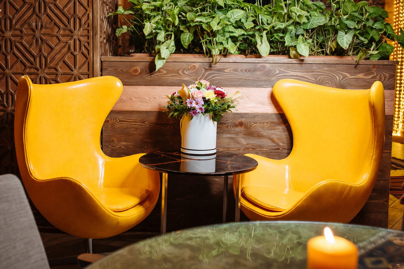 Poltronas de couro amarelo ao lado de uma mesa de centro no salão do restaurante